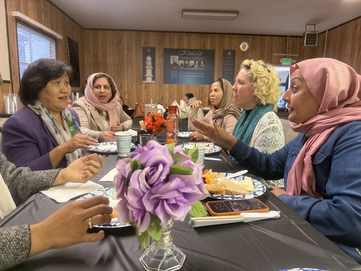 Liang Chao in conversation with women at a faith-community gathering